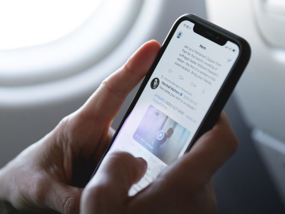 Phone screen as plane passenger browses Twitter
