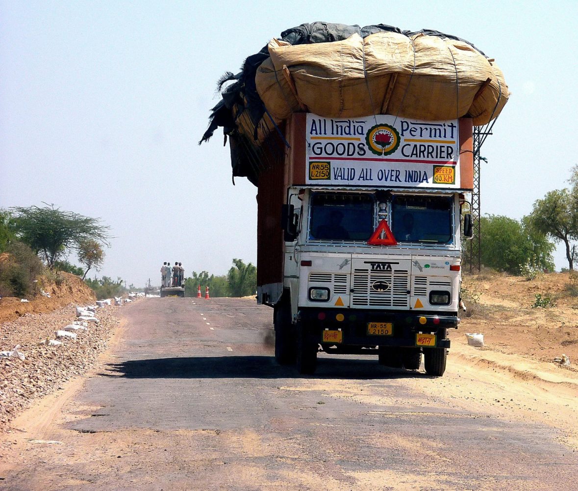 Loaded Tata truck drives along a dusty road