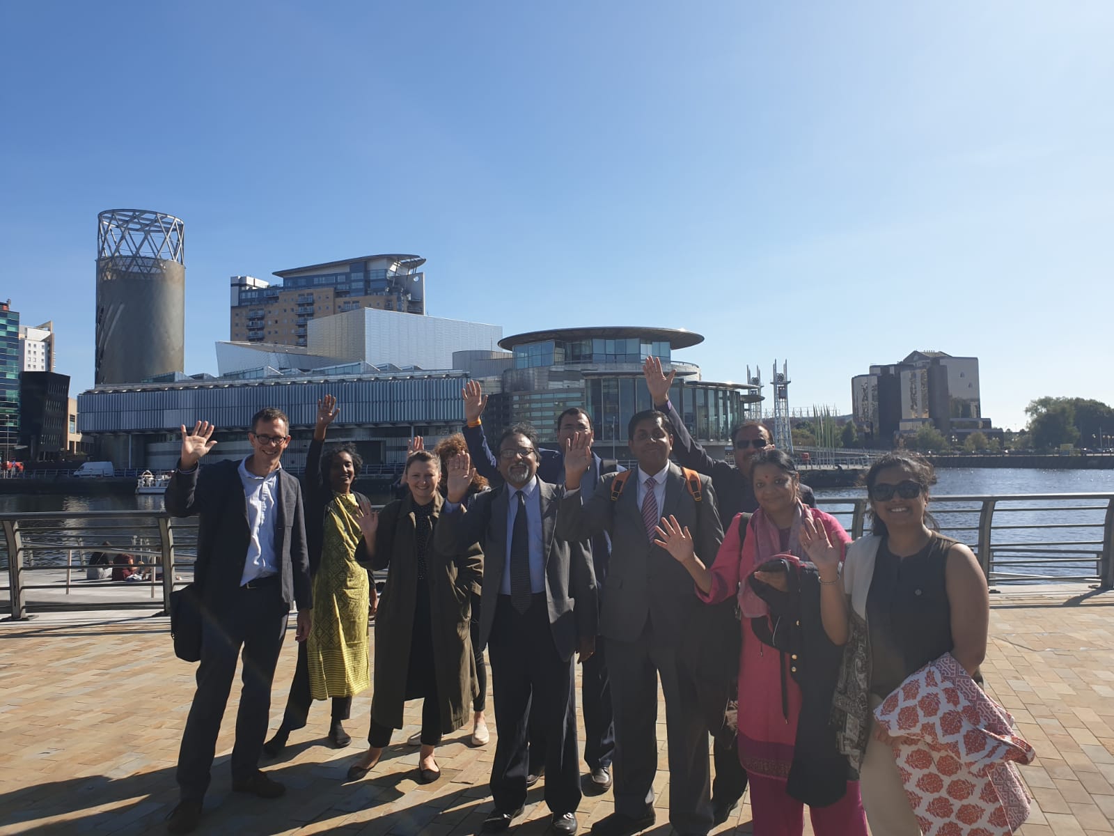 Under Reform team and guests wave in front of buildings at Salford's Media City UK.